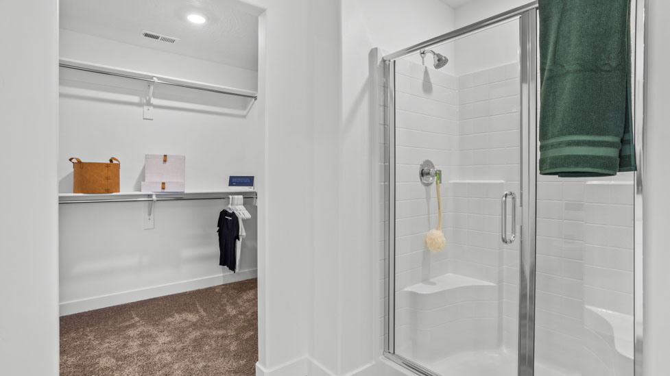 Large primary bathroom with quartz countertops, double sink vanity, and separate walk in shower and garden tub with window