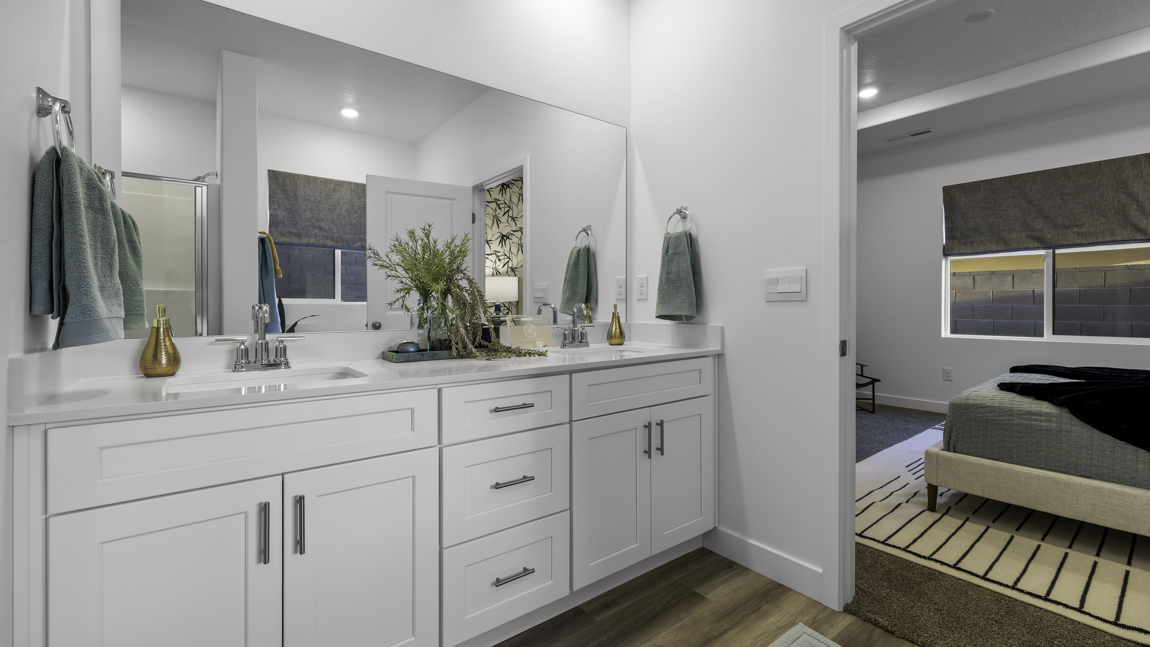 Large primary bathroom with quartz countertops, double sink vanity, and separate walk in shower and garden tub with window