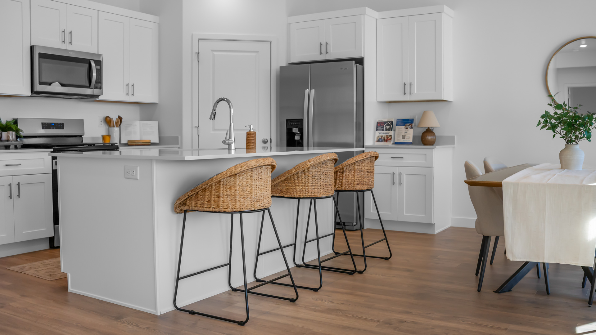 Kitchen area with kitchen sink at island, cabinets, and stainless steel appliances.