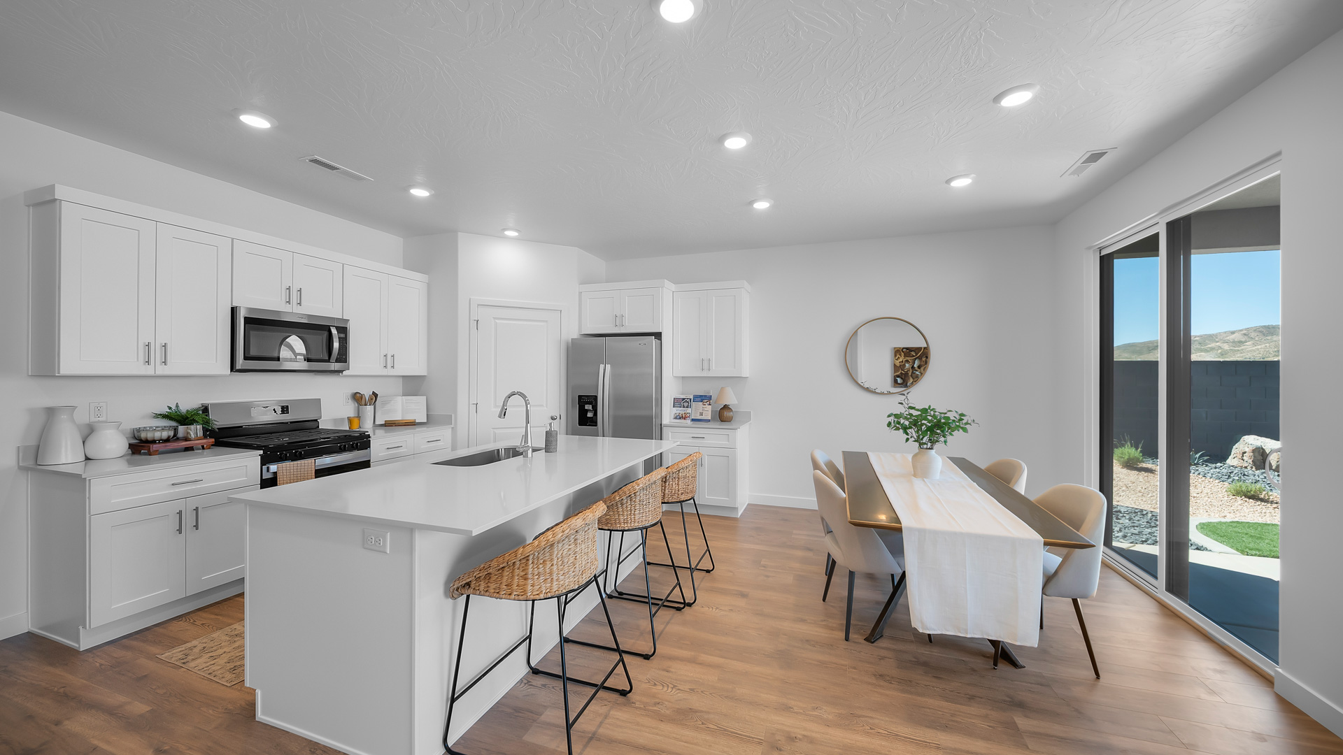 Kitchen area with kitchen sink at island, cabinets, and stainless steel appliances.