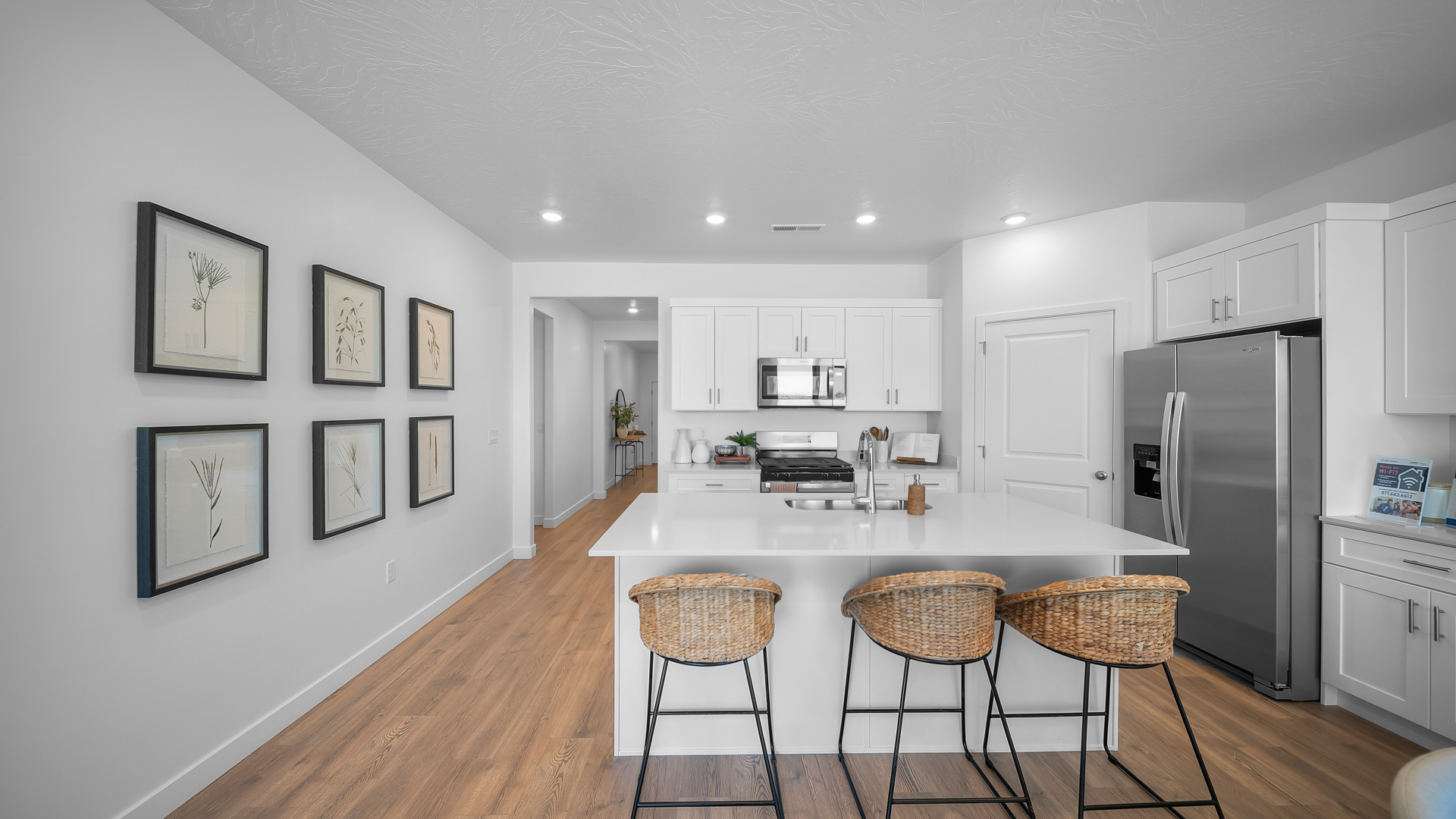 Kitchen area with kitchen sink at island, cabinets, and stainless steel appliances.
