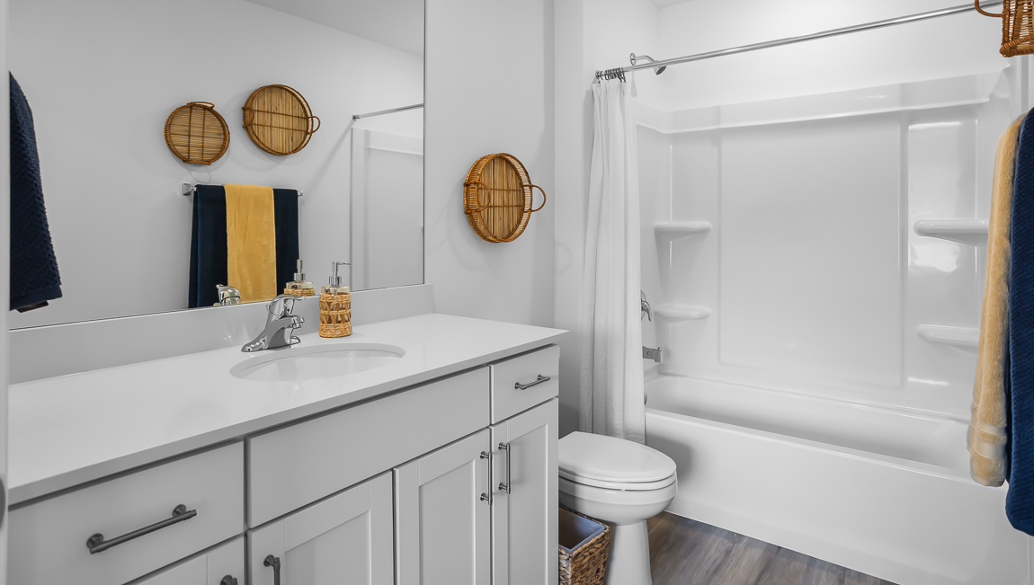 Primary bathroom with white quartz countertops and tub shower