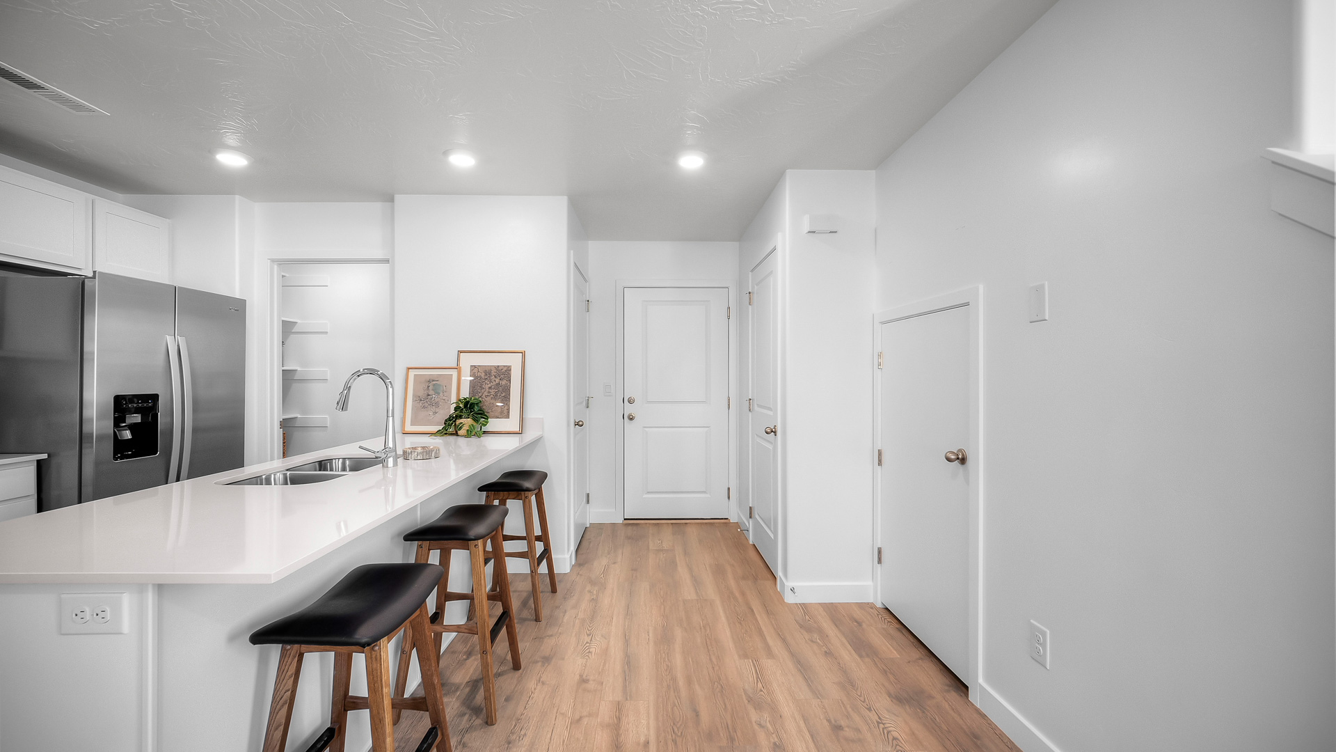 Kitchen with island including quartz countertops, stainless steel appliances, and a roomy walk in pantry.