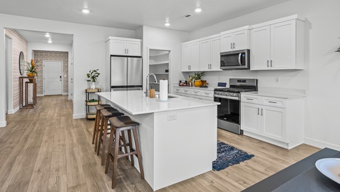 A stunning view from the dining area through the kitchen and to the front entryway of the Stillwater model home in Washington Utah at the Long Valley community by D.R. Horton.