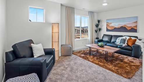 At the top of the stairs on the second level at the Stillwater model home in Long Valley is a spacious loft with two windows.