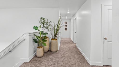 A view down the long and wide hallway to the bedrooms on the second level of the Stillwater floor plan.