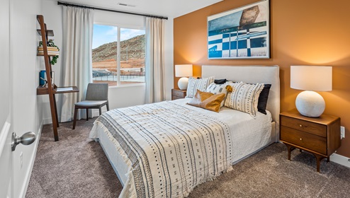 Secondary bedroom with a bed, two side tables and a large window.
