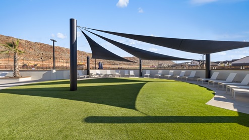 A shaded green area full of lounge chairs overlooking the pool’s festivities at the Long Valley master planned community in Washington Utah.
