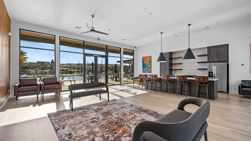Inside the stylish and expansive clubhouse is a large entertaining room and kitchen with an wide breakfast bar chic lighting and huge floor to almost high ceiling windows.