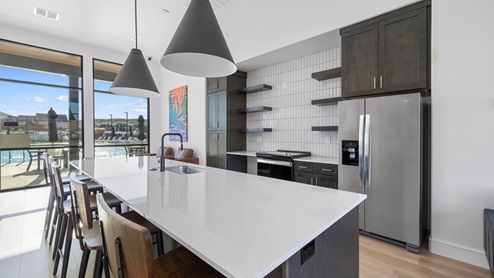 A closer look at the Long Valley clubhouse gathering kitchen that is expansive and stylish, complete with a large breakfast bar with several barstools for entertaining and lounging.