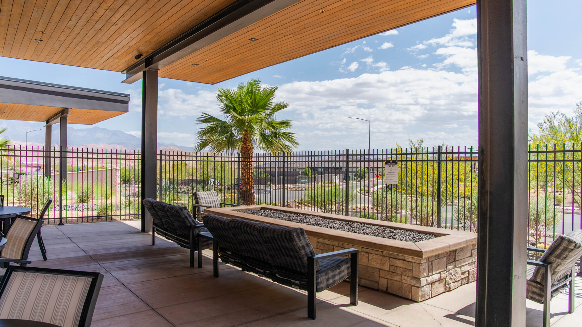 An outside look focusing on the Long Valley clubhouse shaded fire pit entertaining area.