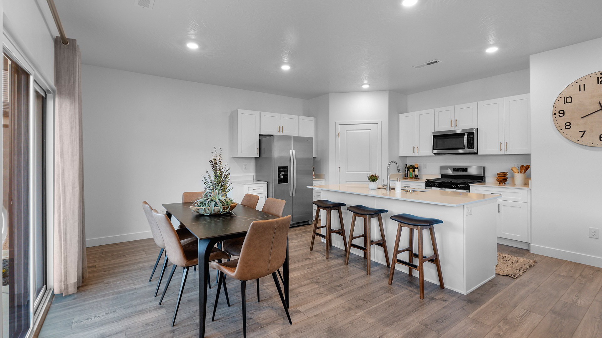 Spacious kitchen with a large quartz island, stainless steel appliances, and corner pantry