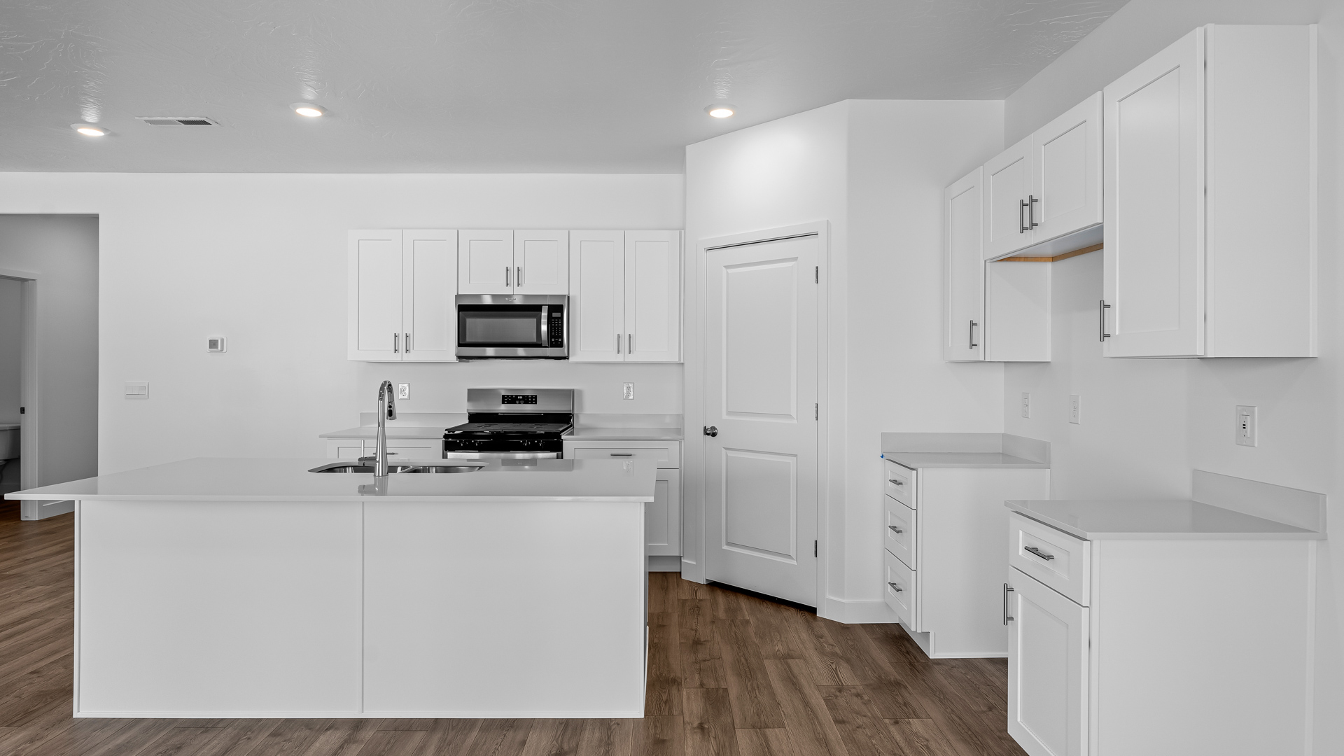 Kitchen space with kitchen island and white cabinets and countertops.
