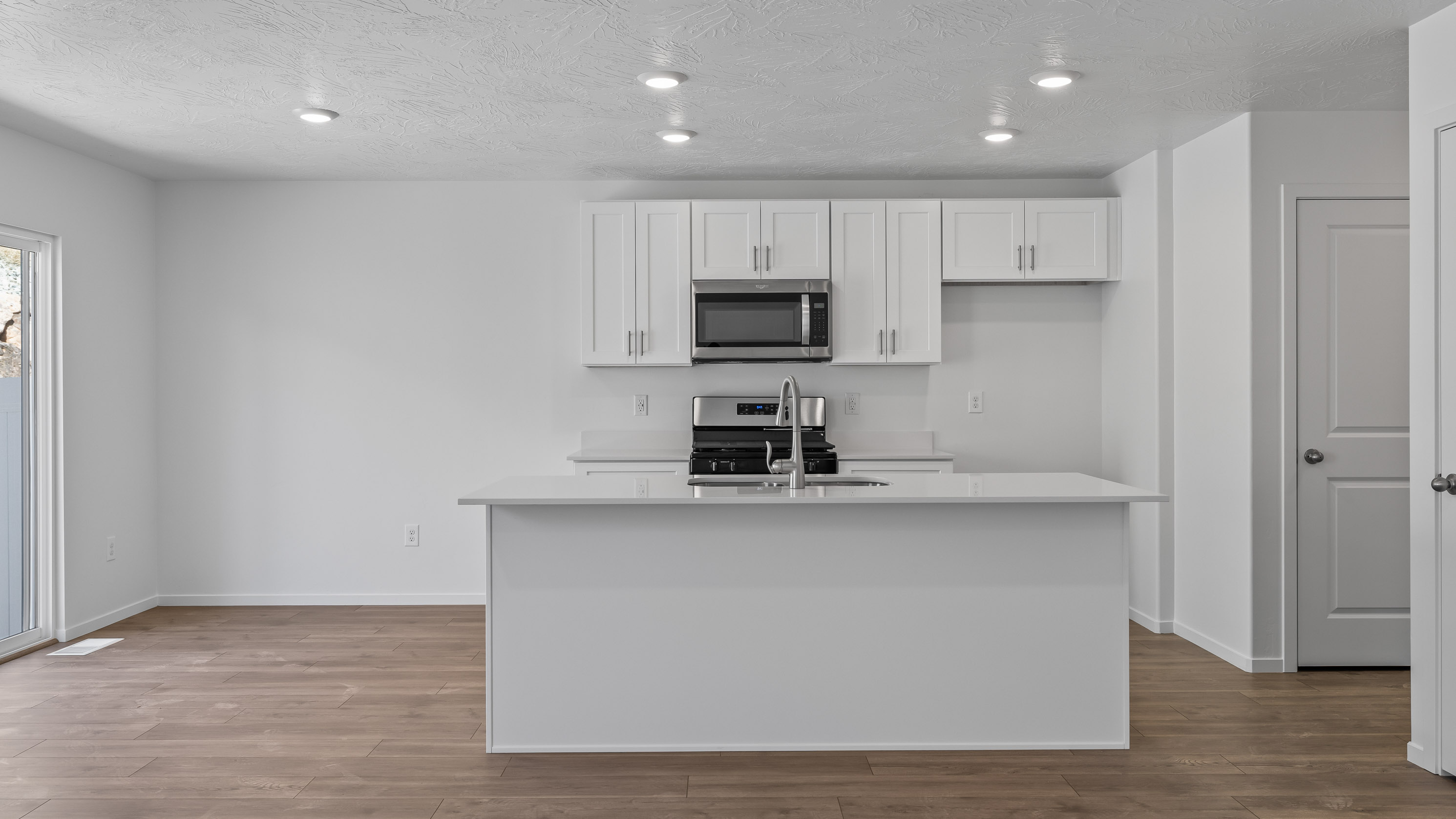 Spacious kitchen with quartz countertops, kitchen island, and pantry