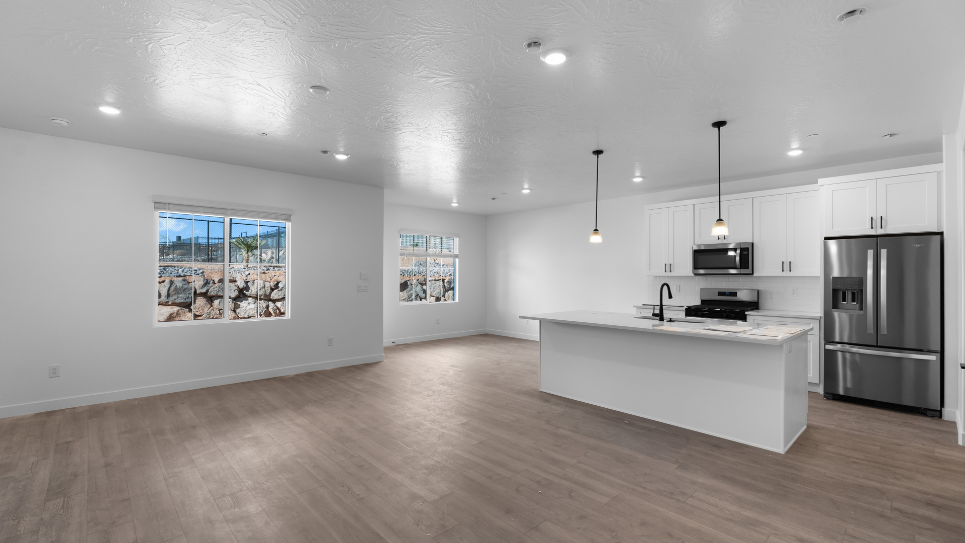 Spacious main living space with kitchen featuring kitchen island and stainless steel appliances.