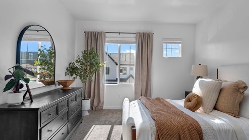 Primary bedroom with large window and two smaller windows.