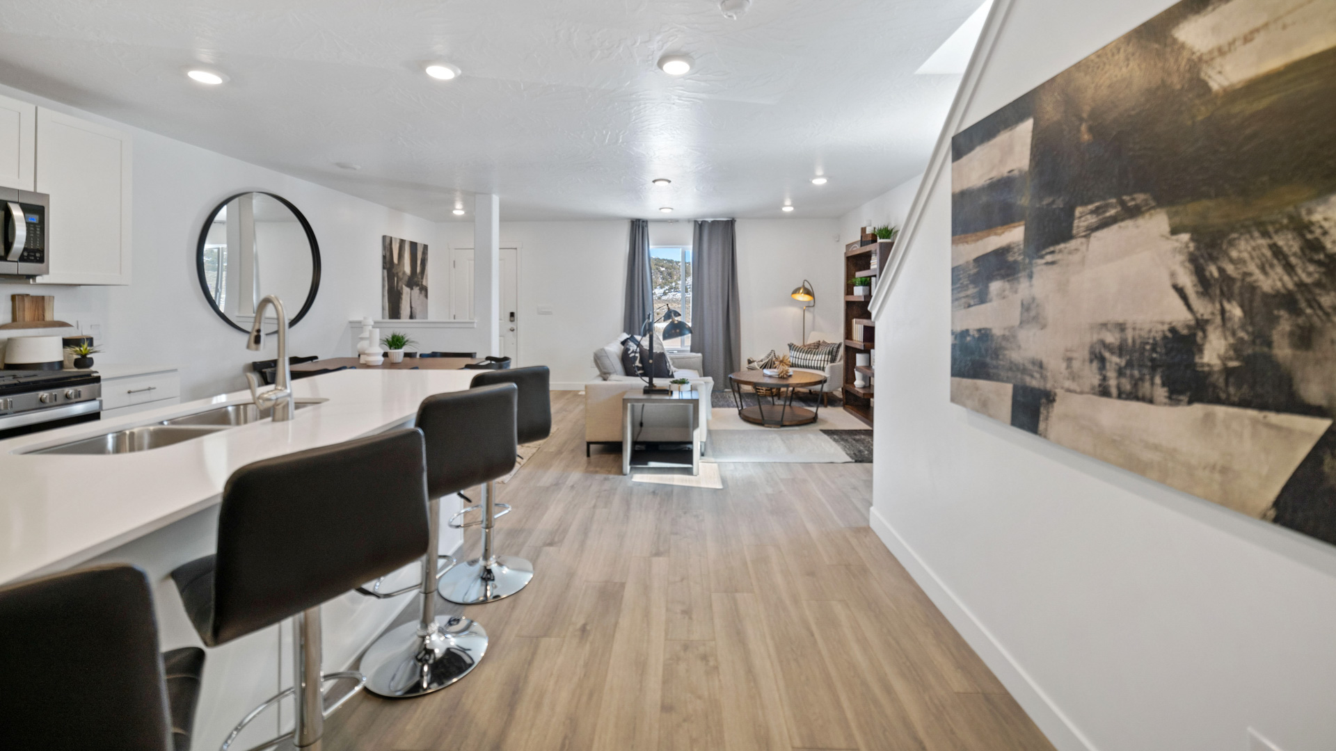 Kitchen space with gray countertops and white cabinets and appliances.