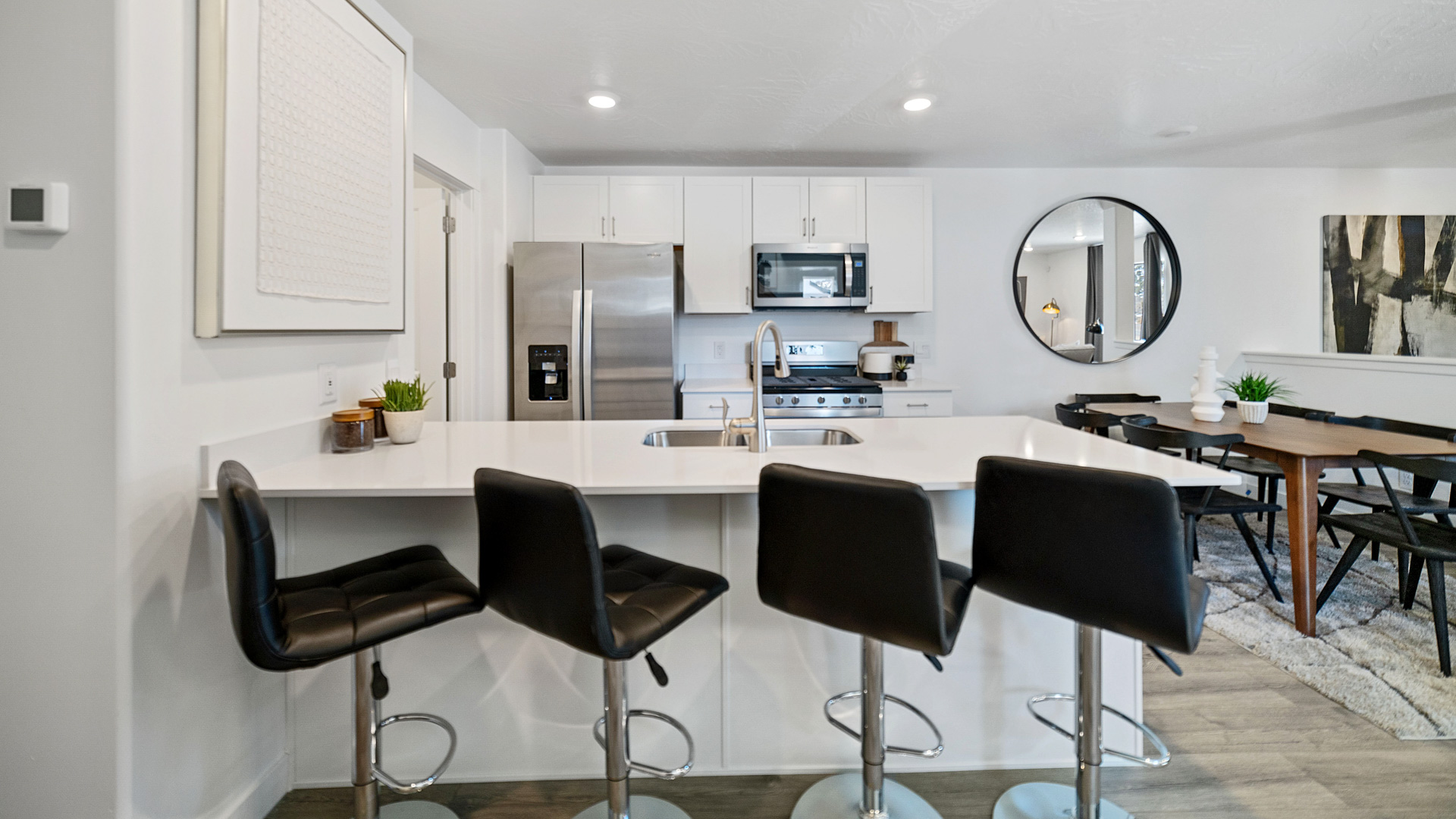 Kitchen space with gray countertops and white cabinets and appliances.