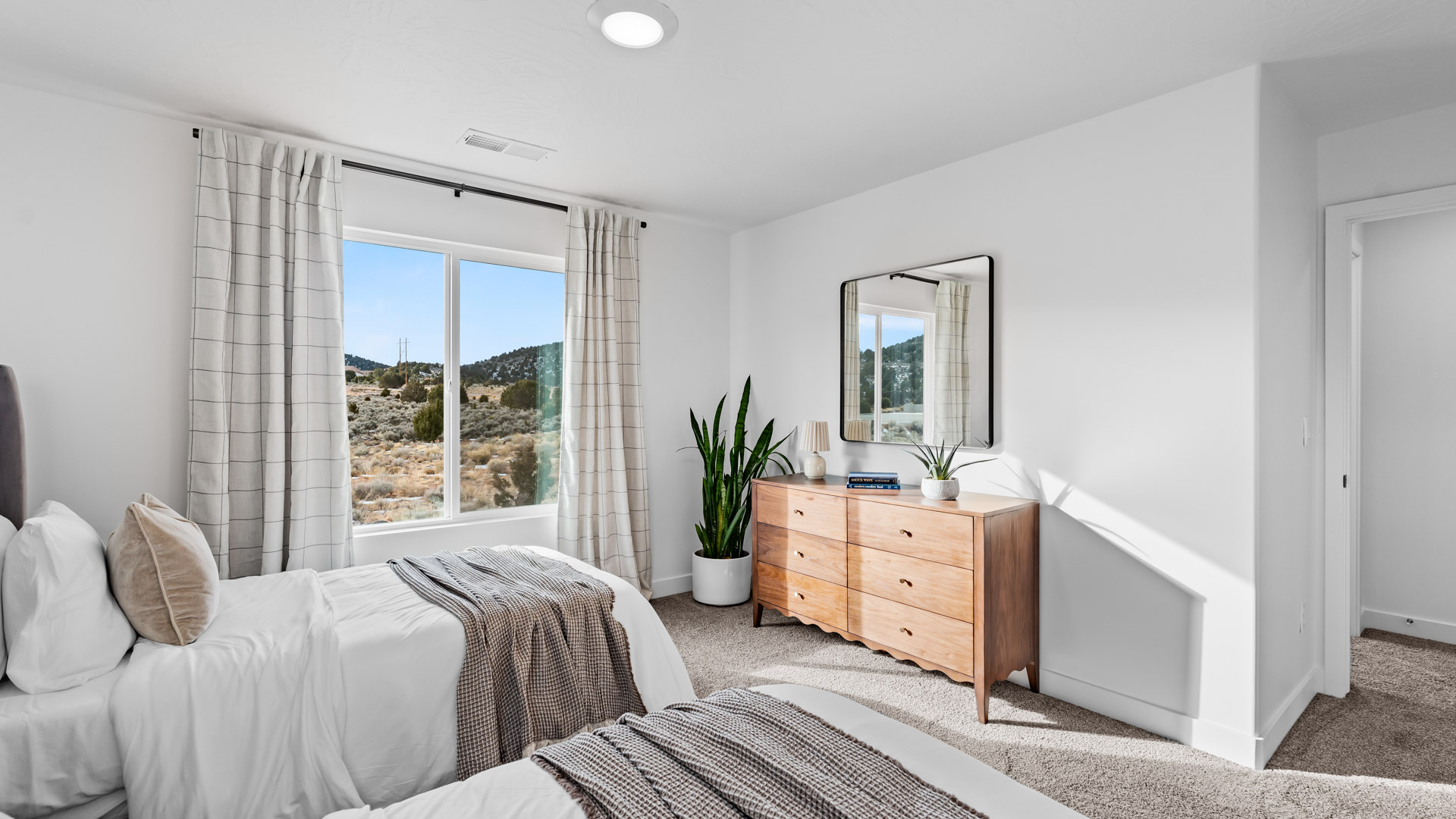 Bedroom with large window and square window in corner.