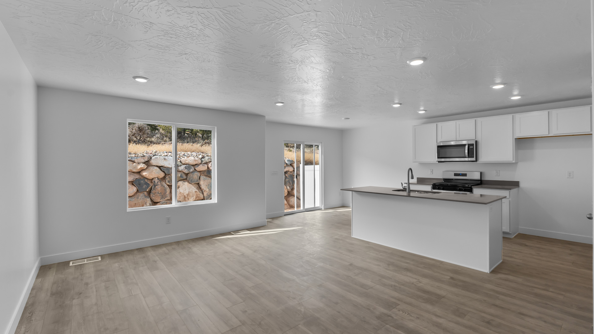 Main living space with windows and kitchen island and dining area.