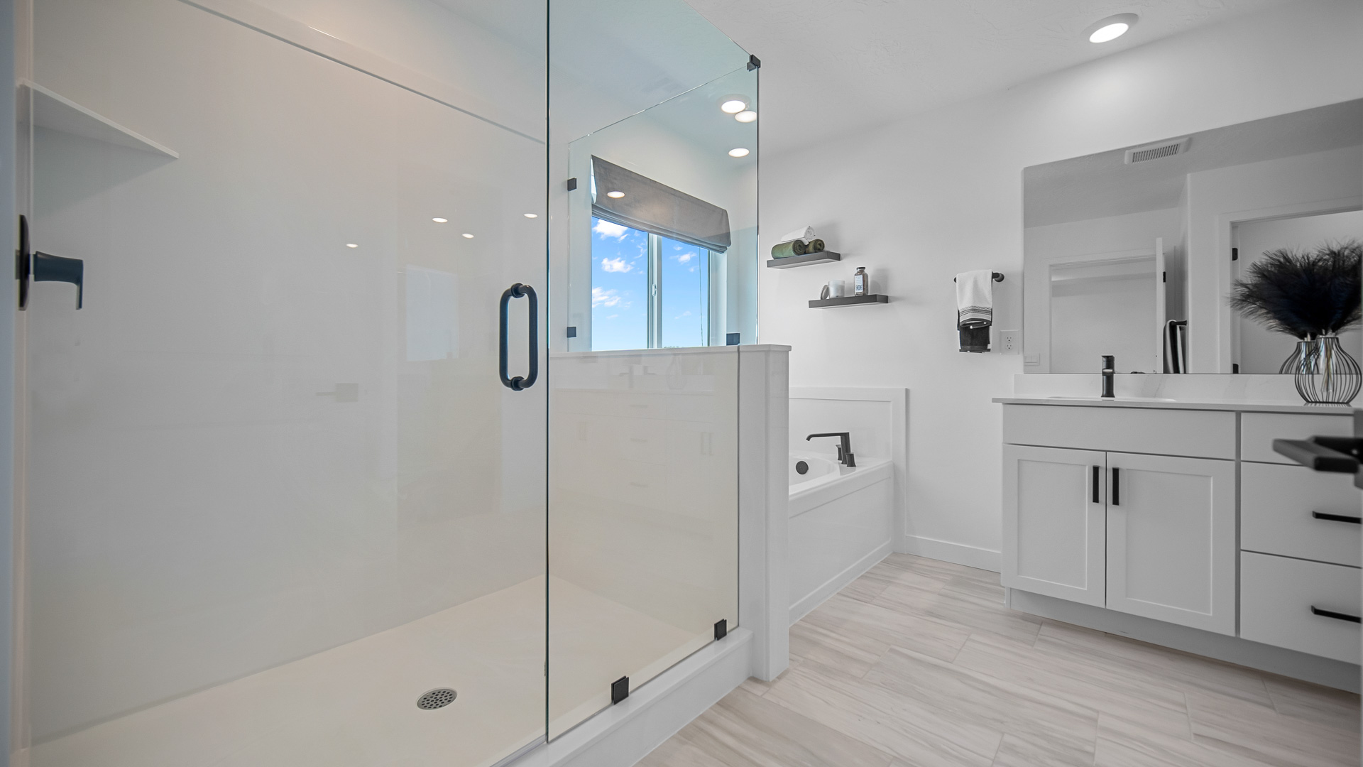 Primary bathroom with double sink vanity, tub, and glass shower.