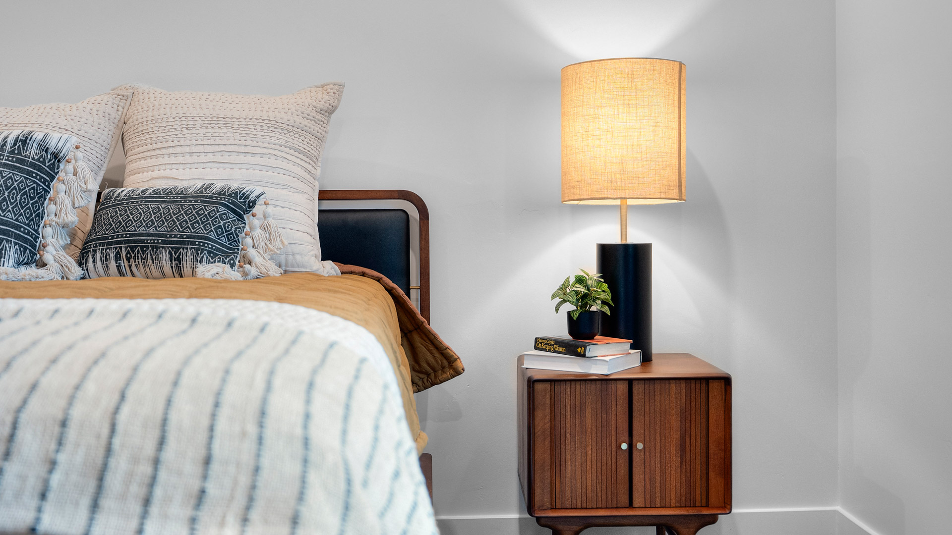 Primary bedroom with tray ceiling and large window.