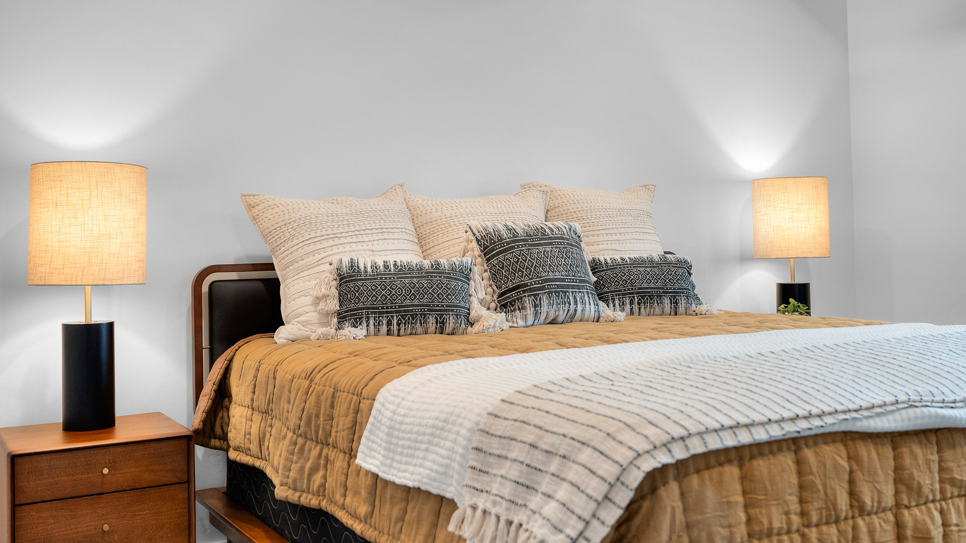 Primary bedroom with tray ceiling and large window.