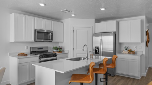 Spacious kitchen with cabinets, island, and stainless steel appliances.