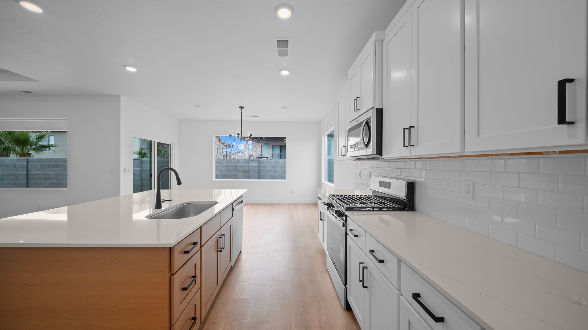 Kitchen with two-tone cabinets and kitchen island with sink.