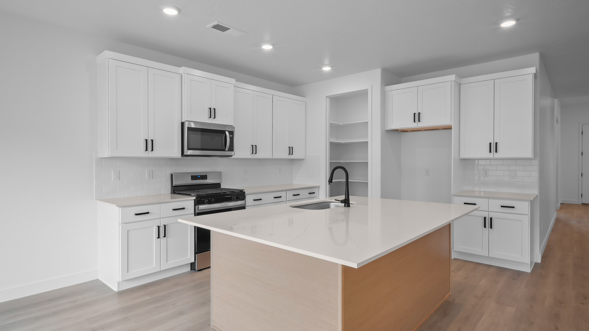 Kitchen with two-tone cabinets and kitchen island with sink.