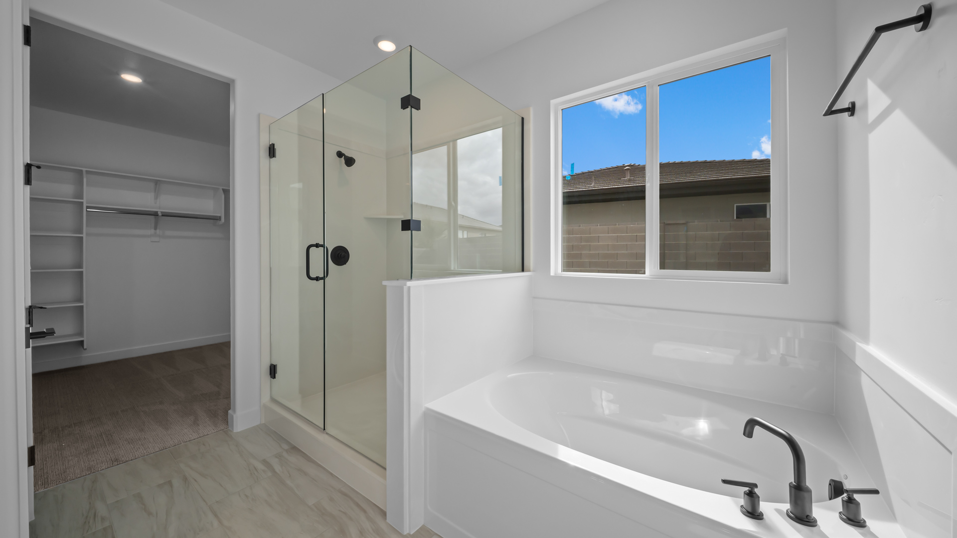 Primary bathroom with double sink vanity, glass shower, tub, and vanity.