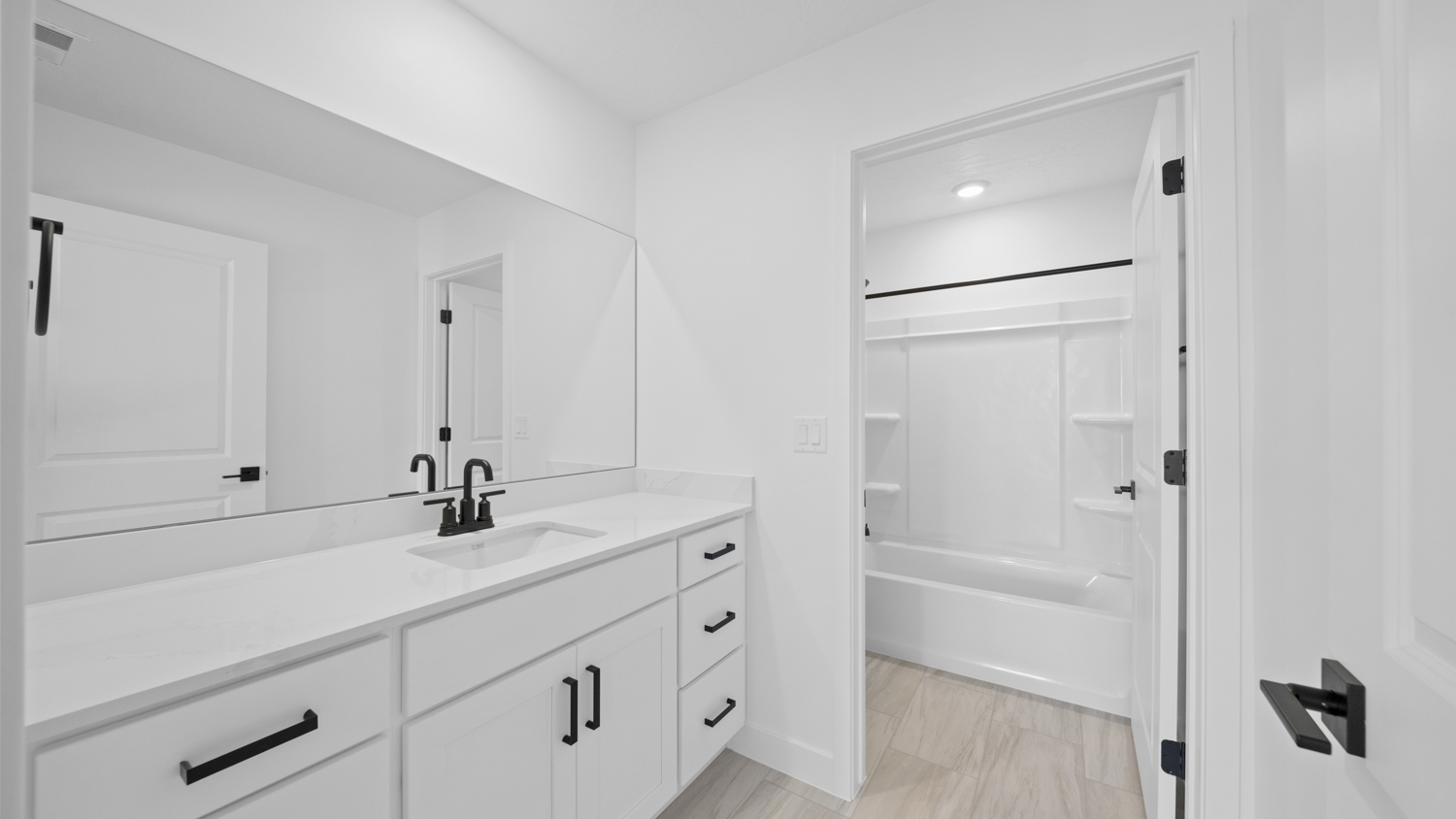 Bathroom with vanity and shower surround.