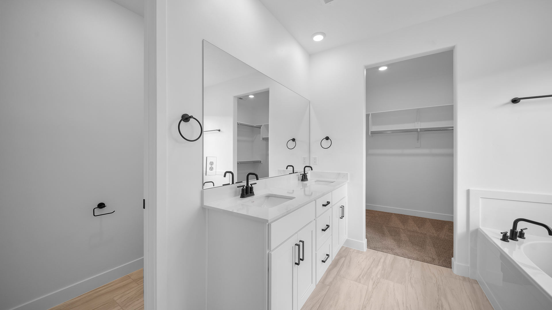 Primary bathroom with double sink vanity, glass shower, and tub.