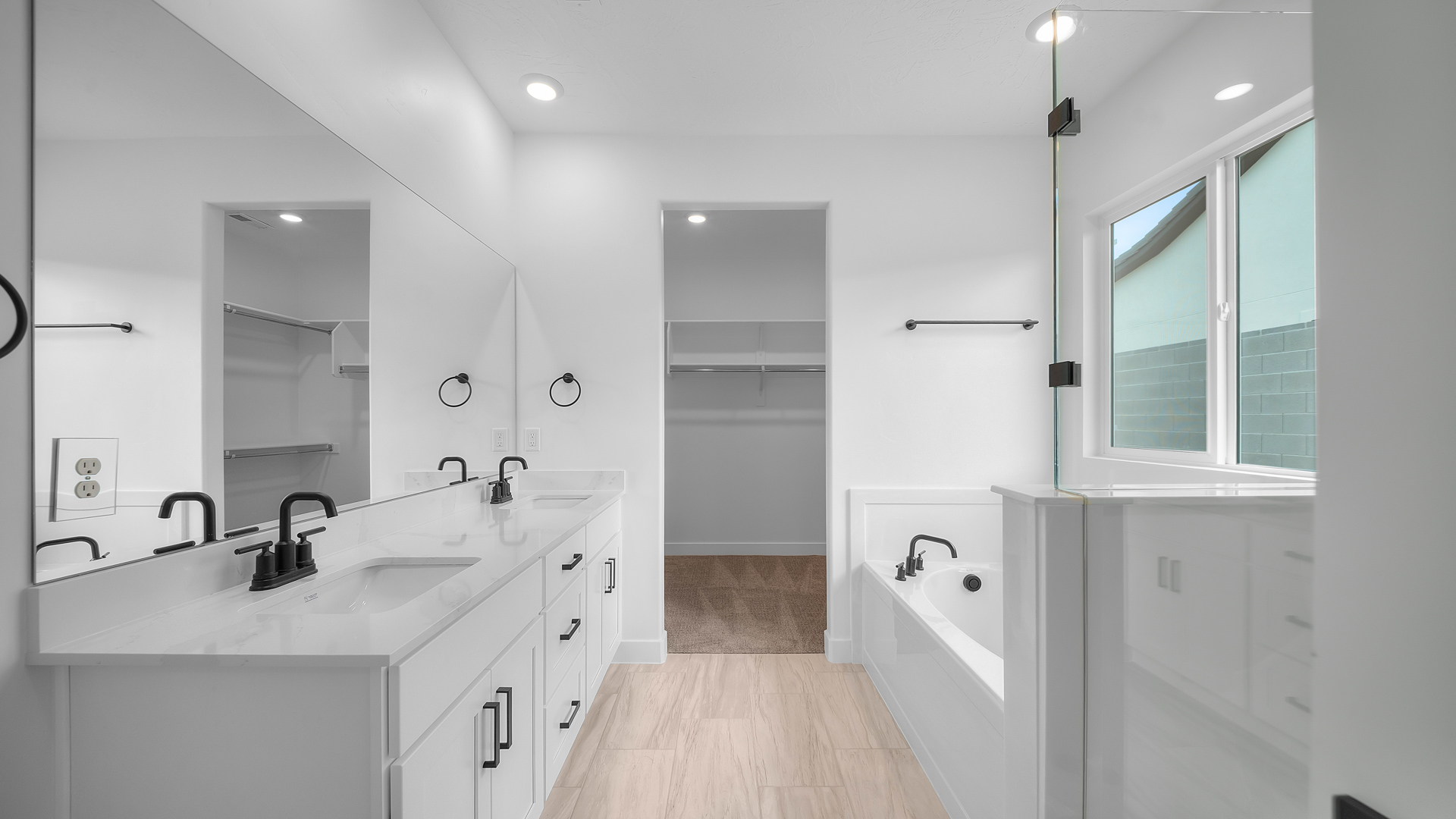 Primary bathroom with double sink vanity, glass shower, and tub.