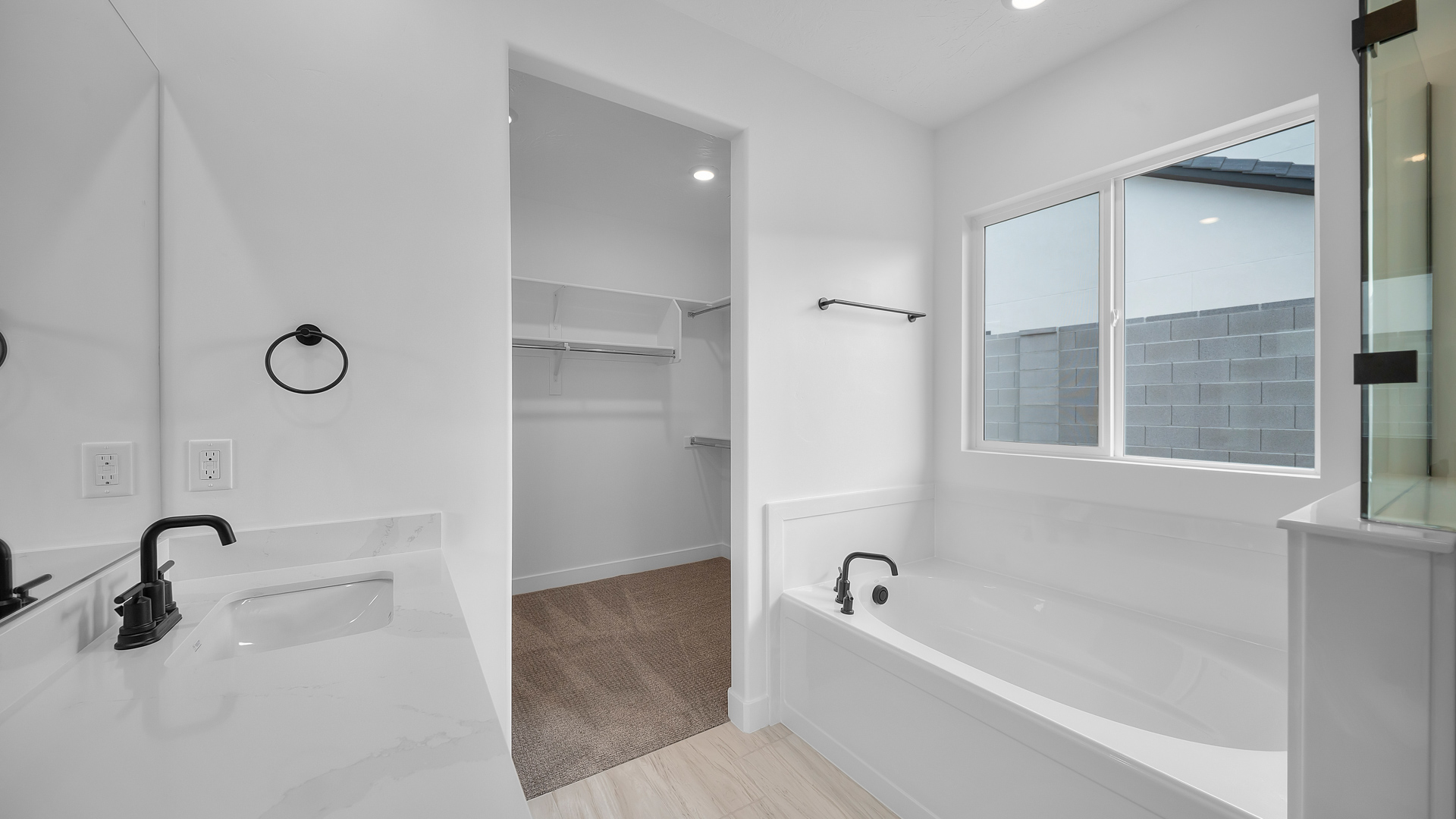 Primary bathroom with double sink vanity, glass shower, and tub.