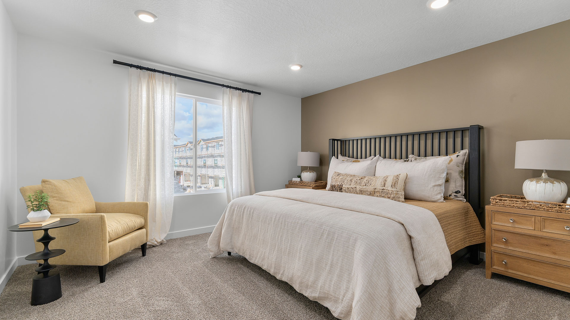 Primary bedroom with large window and beautifully furnished.