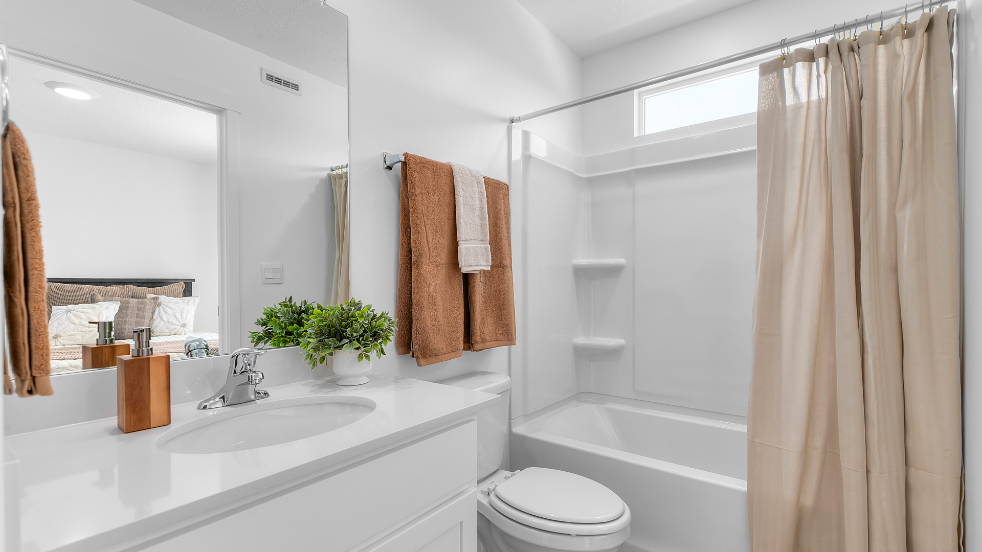Large full-size bathroom for the primary bedroom with window above shower surround.