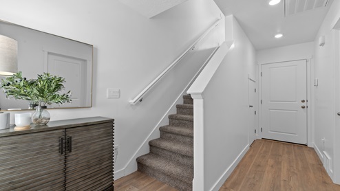 Entry way to townhome with stairs to next level and doors to flex room and bathroom.