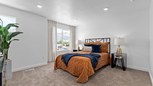Primary bedroom with large window and square window.