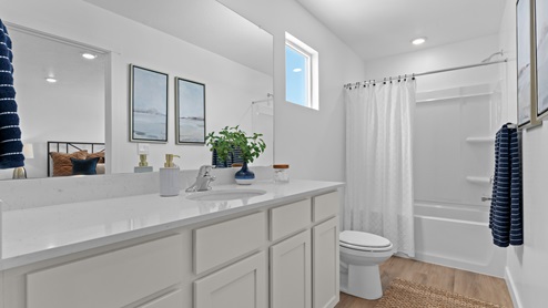 Primary bathroom with square window and shower surround.