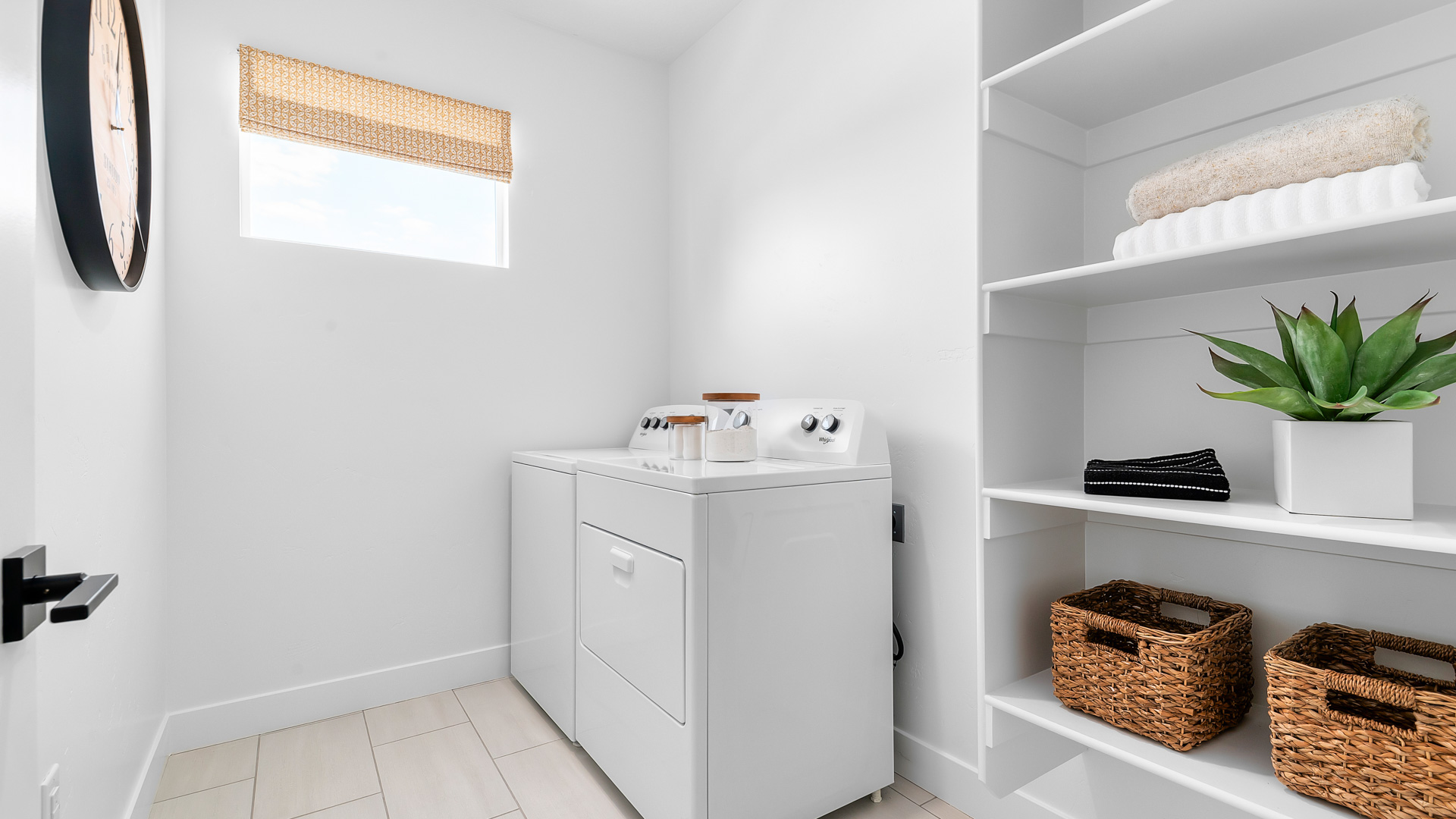 Laundry room with window and shelving storage.