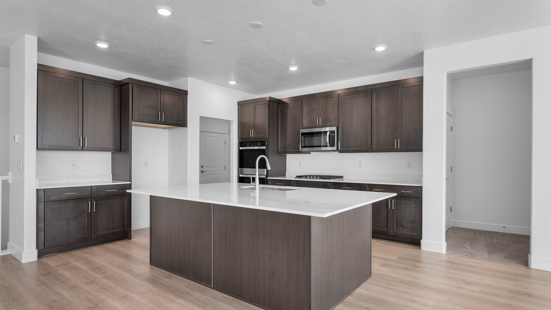 Kitchen with large kitchen island with sink and stainless steel appliances.