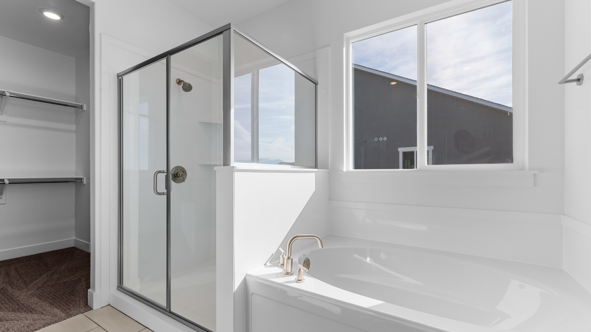 Primary bathroom with shower and bath with window.