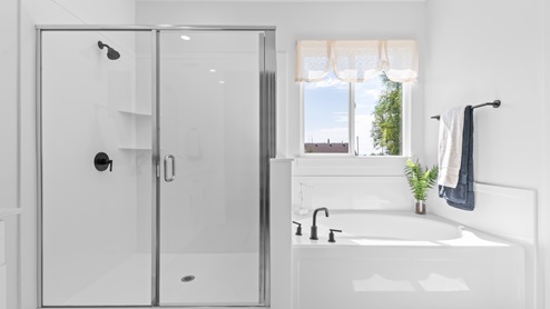 Primary bathroom with bath and glass shower.