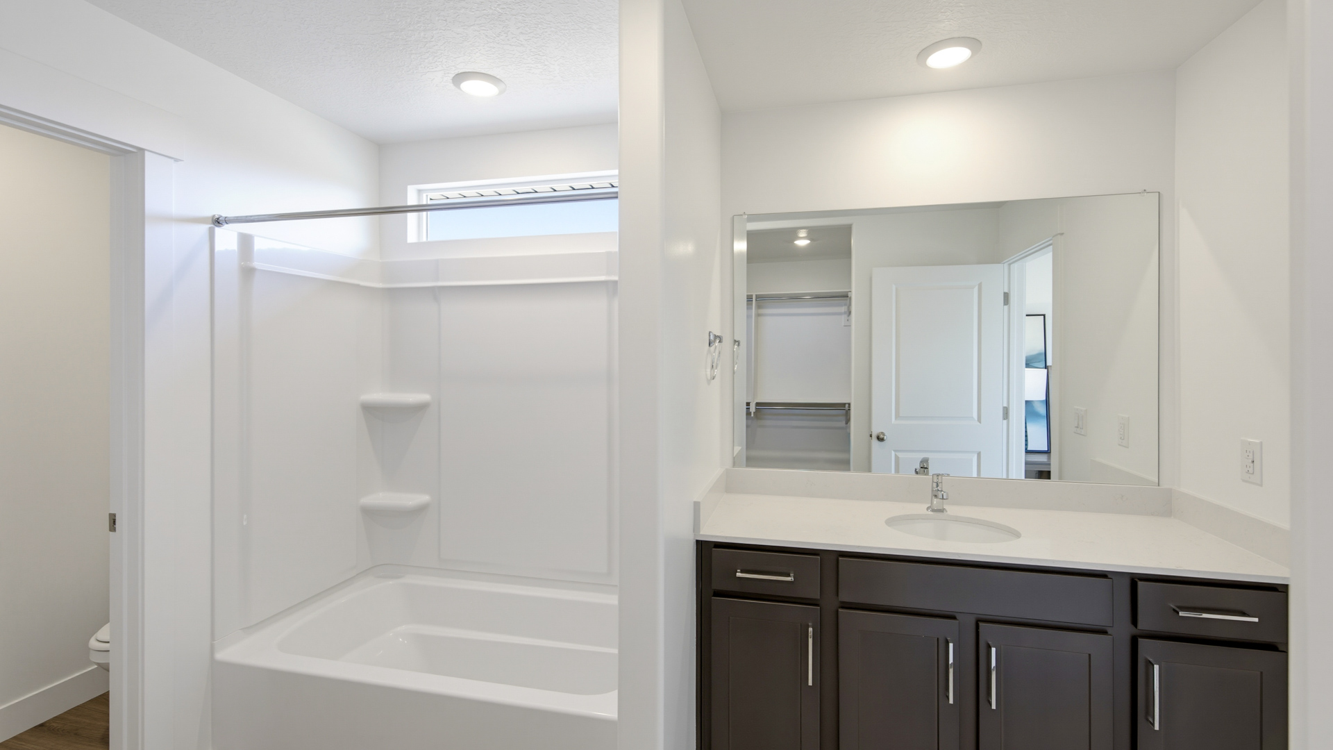 Primary bathroom with shower surround and window above.