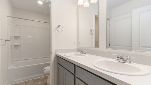 gray cabinet bathroom and a tub