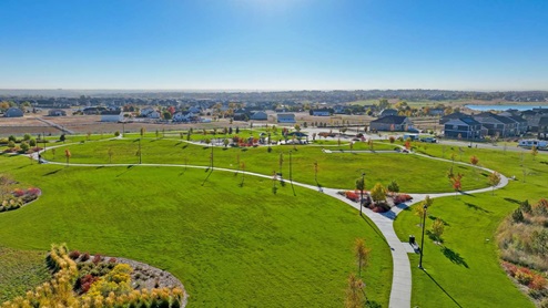 Winding tree-lined walkways, surrounded by grass adjacent to the community