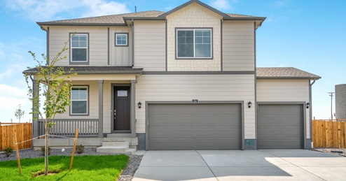Exterior of new two-story ranch-style home with three car driveway and two garage doors in Thornton, Colorado
