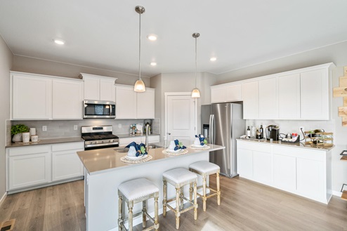 This plan features a kitchen with white cabinets, quartz counter tops, stainless steel appliances, corner pantry, and central island.