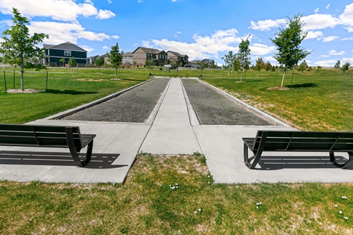 Park benches side-by-side overlooking two bocce ball pits